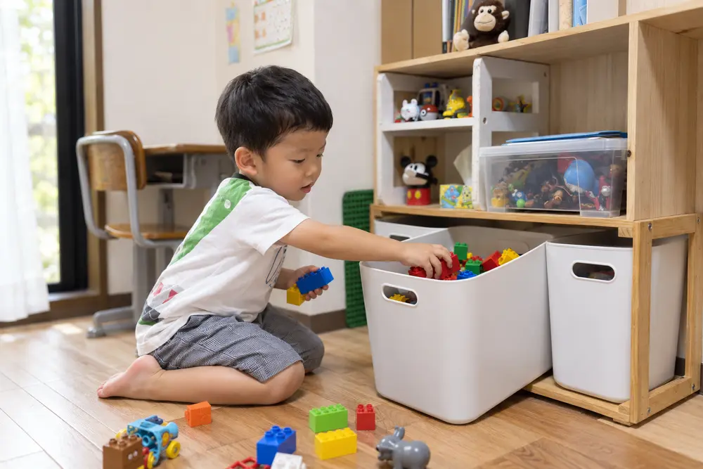 子どもの手が届くかごに、自分でおもちゃを戻す工夫を表すイメージ写真